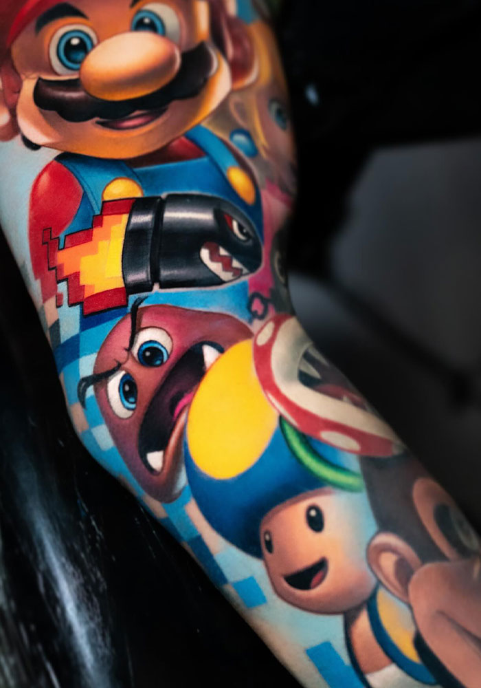 Colorful Mario tattoo with game characters on a person's arm.