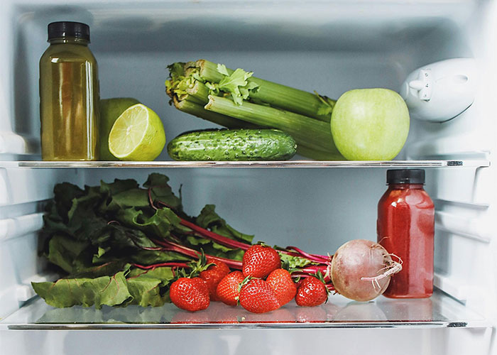 A fridge with fresh fruits, vegetables, and juices showing a glimpse of how others live and eat simply.