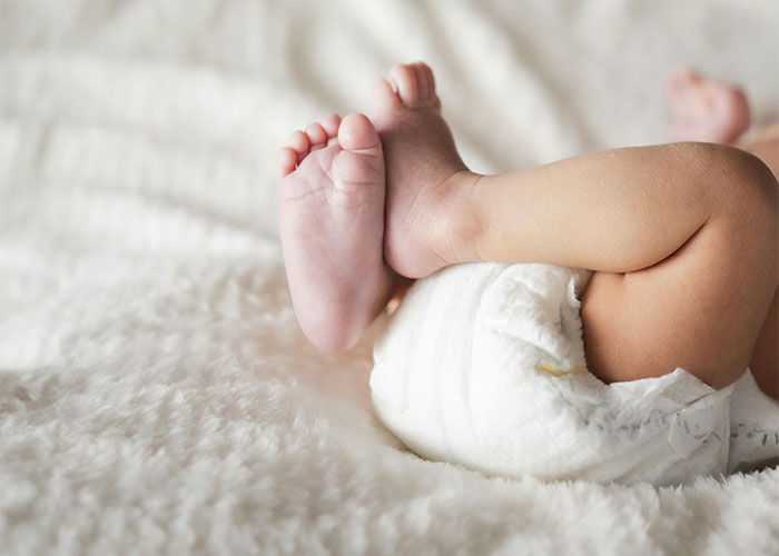 Close-up of baby feet resting on a soft blanket, illustrating surprising moments people were shocked by how others live.