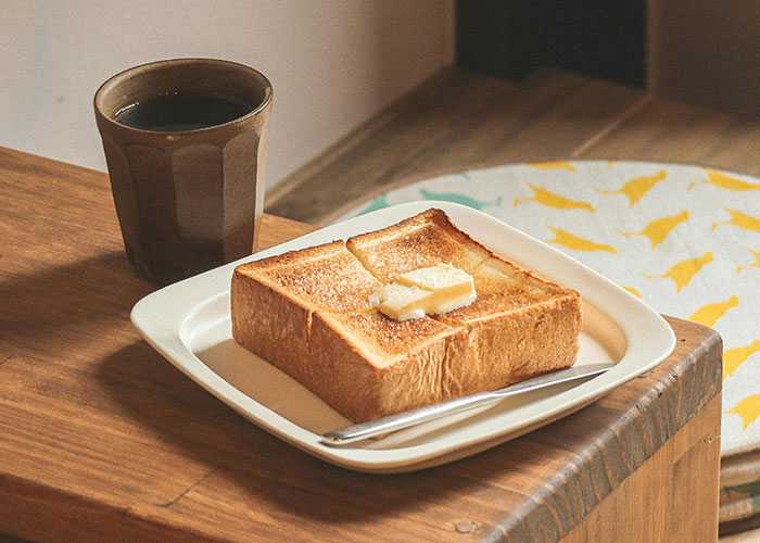 A simple breakfast of toasted bread with butter and a cup of coffee, illustrating everyday life moments people notice.