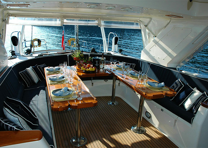 Luxury yacht dining area with elegant table settings and comfortable seating, showcasing surprising living spaces on water.