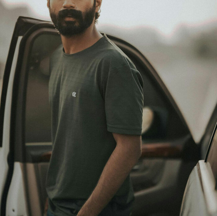 Man with a beard wearing a dark shirt, standing by an open car door, related to unfortunate baby names. - 4