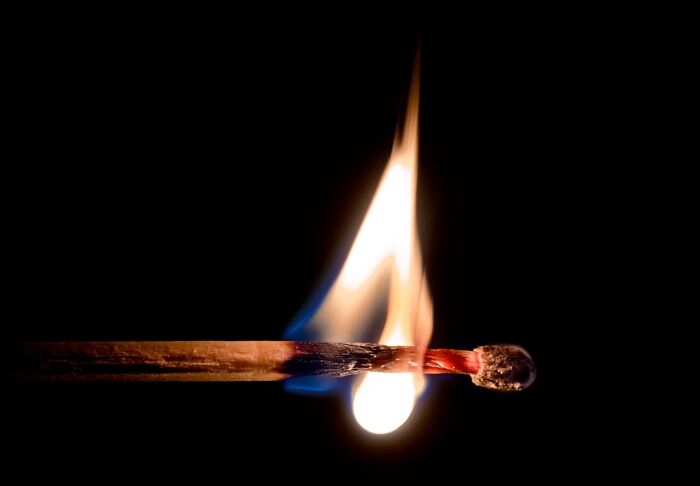 A matchstick burning against a dark background, symbolizing unfortunate names and unexpected outcomes. - 22