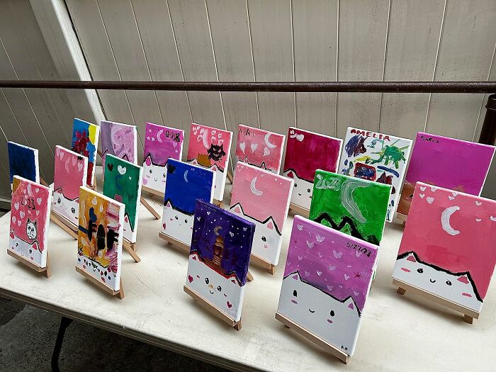 Colorful array of small, whimsical paintings displayed on easels for artistic souls to explore.