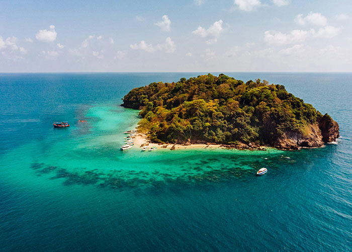 Private tropical island surrounded by clear ocean water, showcasing one of the wildest things the rich can purchase.