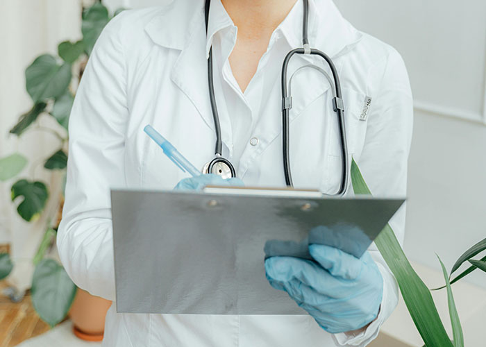 Doctor wearing a white coat and gloves, holding a clipboard and pen, representing wildest things the rich can purchase.