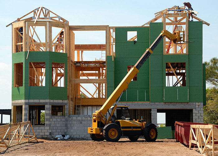 Construction of a luxury home using heavy machinery and wooden framing, an example of wild things the rich can purchase.
