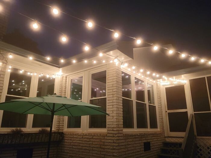 Outdoor garden patio with string lights and a green umbrella, showcasing low-effort garden finds for easy decor.