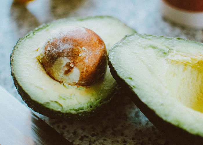 Close-up of a halved avocado on a kitchen counter, illustrating fresh food in unfiltered food opinions discussion.
