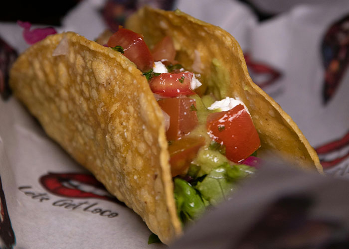 Crunchy taco filled with fresh tomatoes, lettuce, and sour cream highlighting unfiltered food opinions and crunchy vinegar flavors