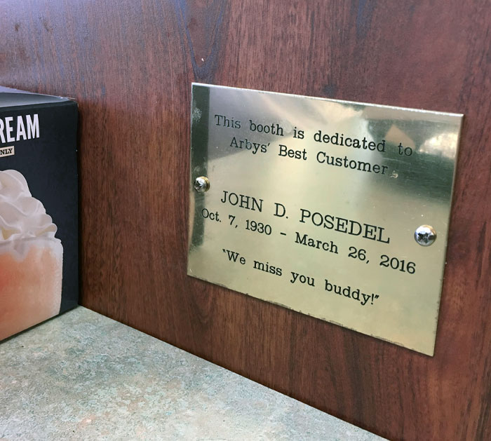 Memorial plaque in a restaurant booth dedicated to the best customer, showcasing a heartfelt tribute idea.