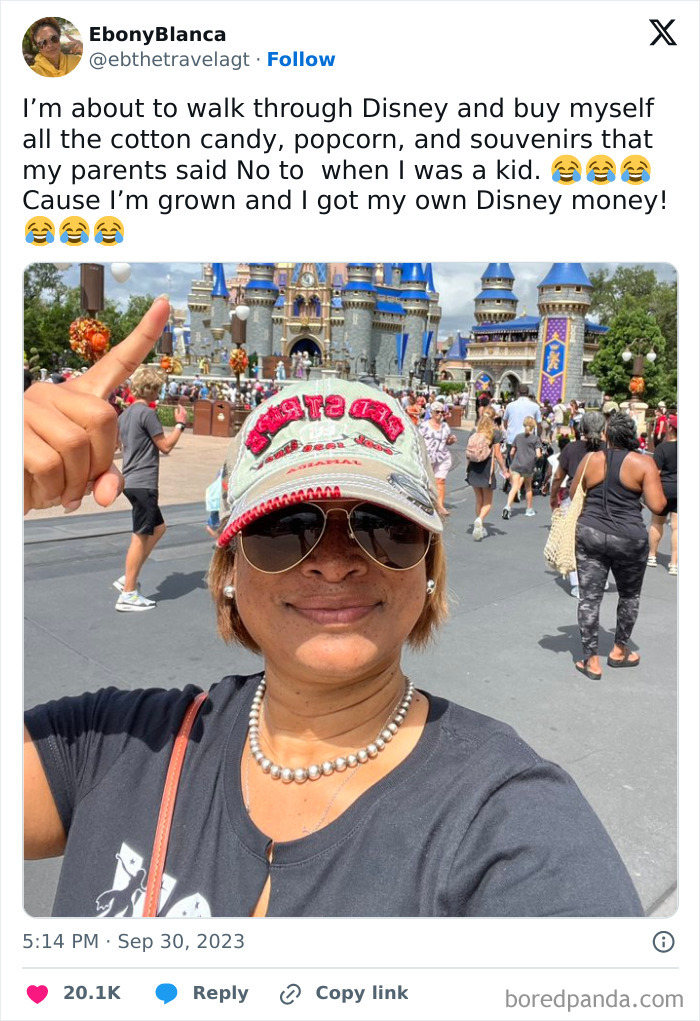 Selfie of a woman smiling in front of Disney castle, wearing sunglasses and a cap, capturing a fun Disney adult moment.
