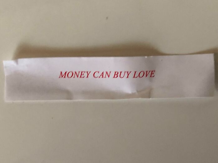 Fortune cookie fail with text "Money Can Buy Love," showcasing a humorously incorrect message.
