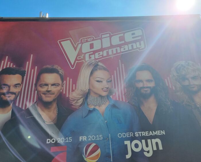 Billboard with distorted faces, captioned "The Voice of Germany," showcasing a humorous design fail.