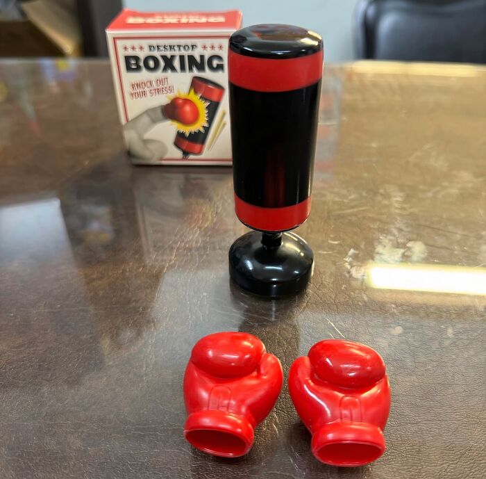 Mini desktop punching bag with red boxing gloves on a table, a novelty find for a dopamine hit.