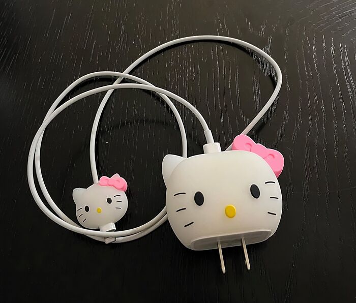 Hello Kitty-themed charger and earphones on a black wooden surface, a novelty find for a dopamine hit.
