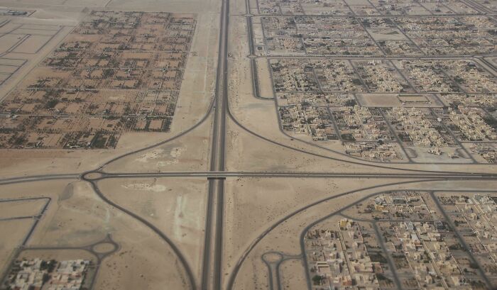 Aerial view of brilliant infrastructure showing a desert highway interchange connecting urban residential areas.