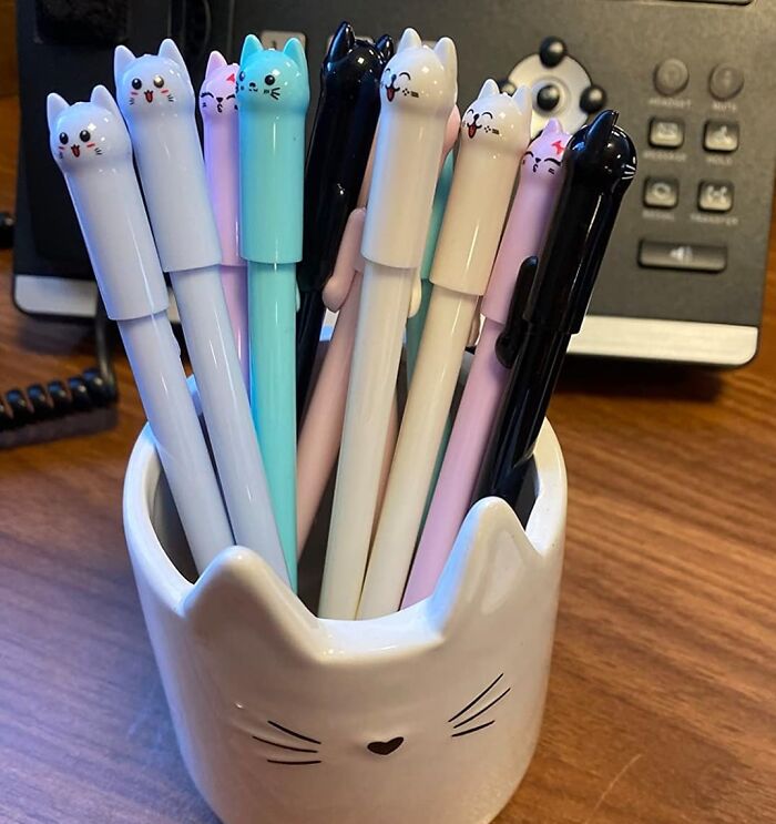Cat-themed colorful pens in a cute ceramic holder on a desk, offering an instant mood lift and joyful vibe.