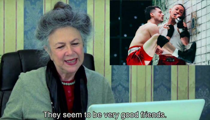 Elderly woman laughing at a Eurovision Song Contest meme on her laptop screen.