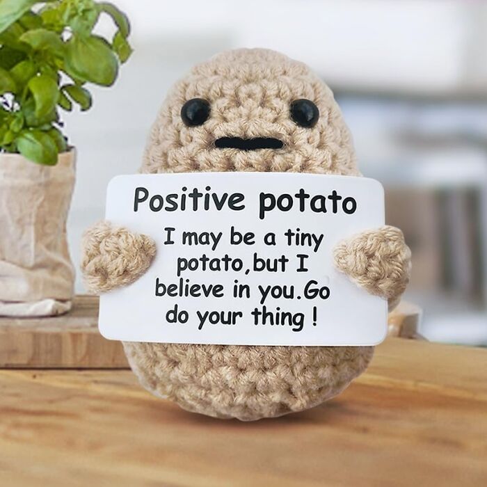 Crocheted positive potato holding an encouraging sign, one of the random things borderline genius and want them all.
