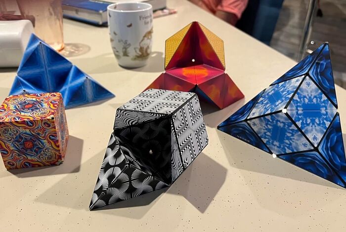 Colorful geometric shapes with intricate patterns displayed on a table, showcasing creative and borderline genius designs