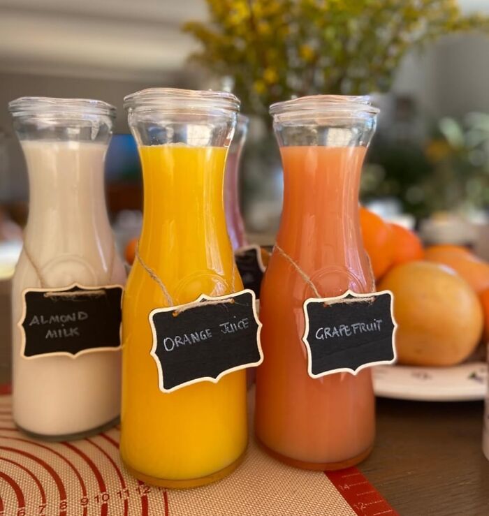 Glass bottles labeled almond milk, orange juice, and grapefruit, perfect to reinvent your fridge and pantry organization.