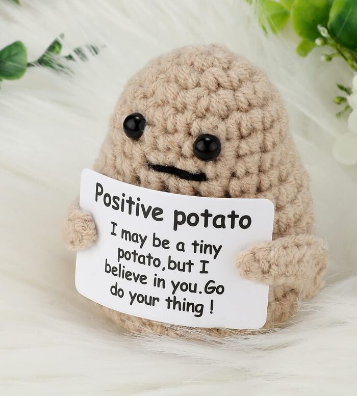 Crocheted positive potato plush holding an inspirational sign, one of the trending products in the Pandaverse virtual marketplace.
