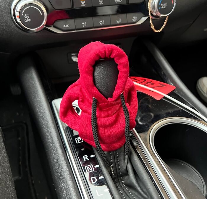 Car gear shift covered with a small red hoodie, showing a creative and borderline genius random car accessory idea.
