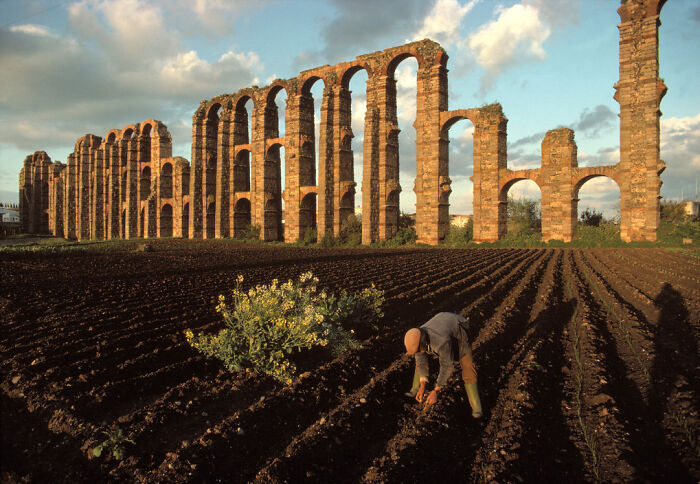 Tilling The Fields In The Shadow Of The Ruins Of Roman Aquaducts. Spain, Merida. Date: 1990. Photographer: Bruno Barbey