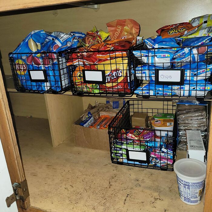 Organized pantry with baskets of snacks and chips for a reinvented storage solution.