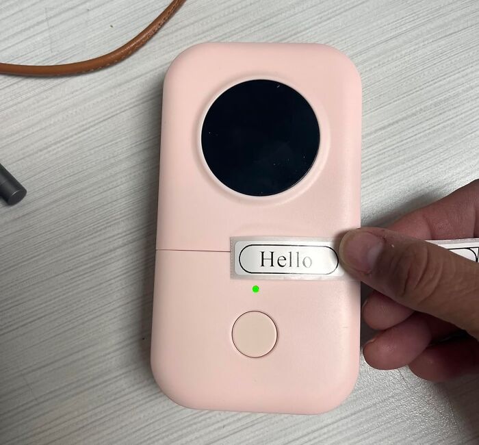 Pink label maker printing "Hello" to organize your fridge and pantry items efficiently.