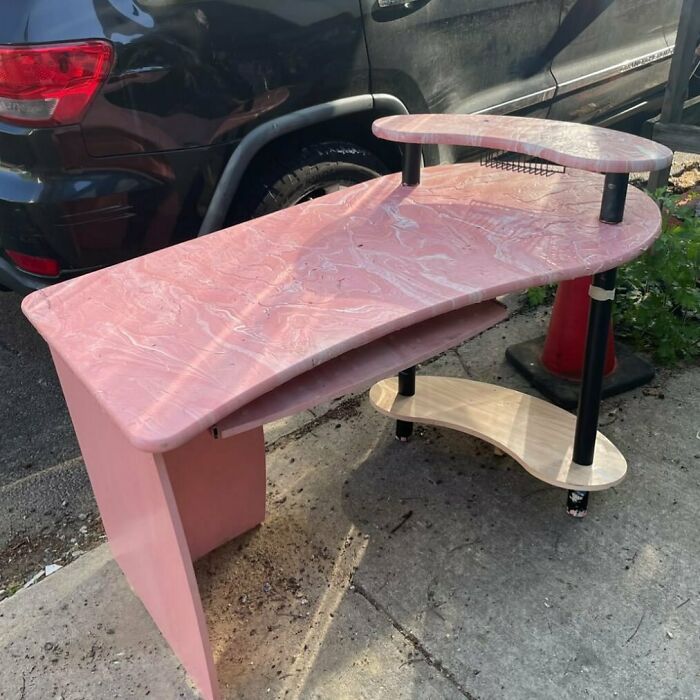Pink desk with multiple tiers left on NYC curb, waiting to be found as a treasure.