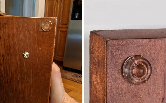 Clear adhesive furniture pads on wooden cabinet corners, one protecting a kitchen door, an everyday find fixing annoyances.