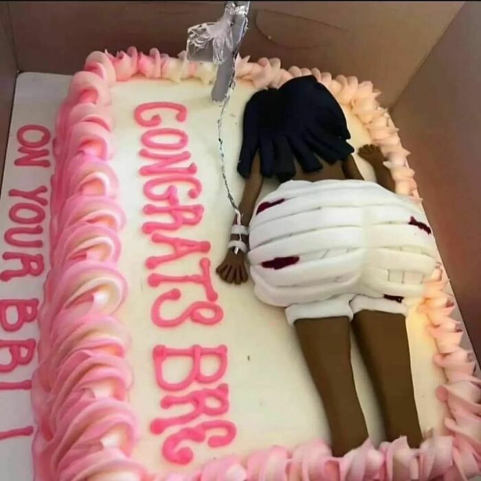 Unappetizing cake with figurine and pink frosting, featuring the message "Congrats" in pink icing.