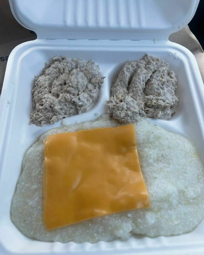 Unappetizing food with mashed mixture and cheese on a white tray.