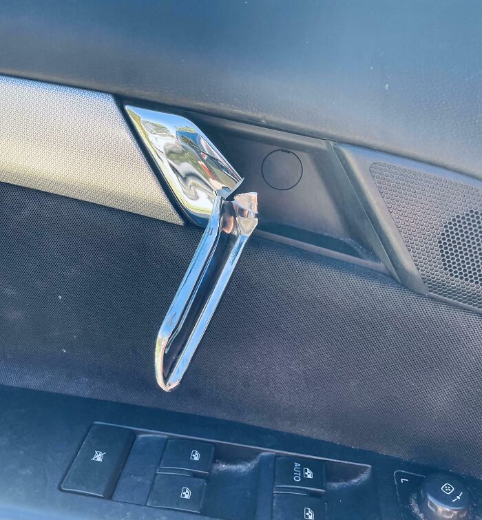 Broken car door handle inside a vehicle, showing damage likely causing parents to have a pretty miserable day.