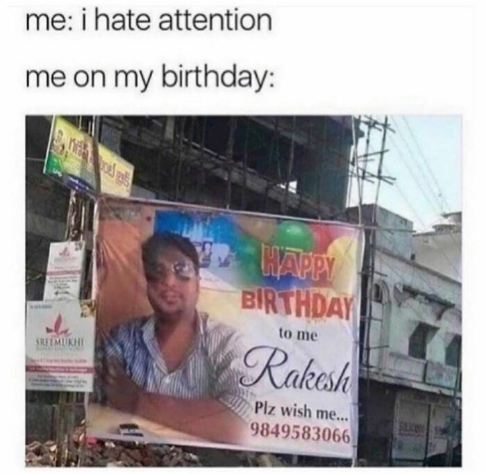 Man humorously displaying a large birthday banner with his photo for attention, despite claiming to dislike it.