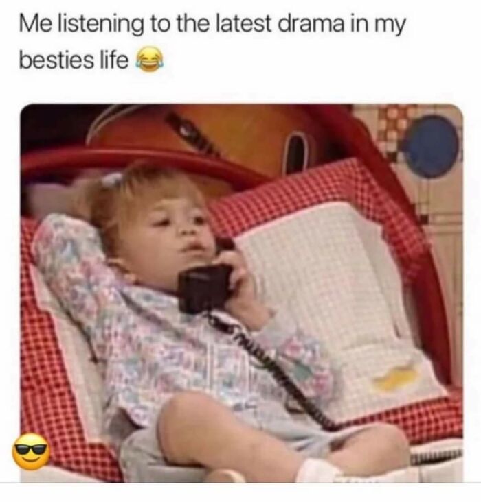 Young child reclining on a bed, holding a phone, representing random memes about shared unique experiences.