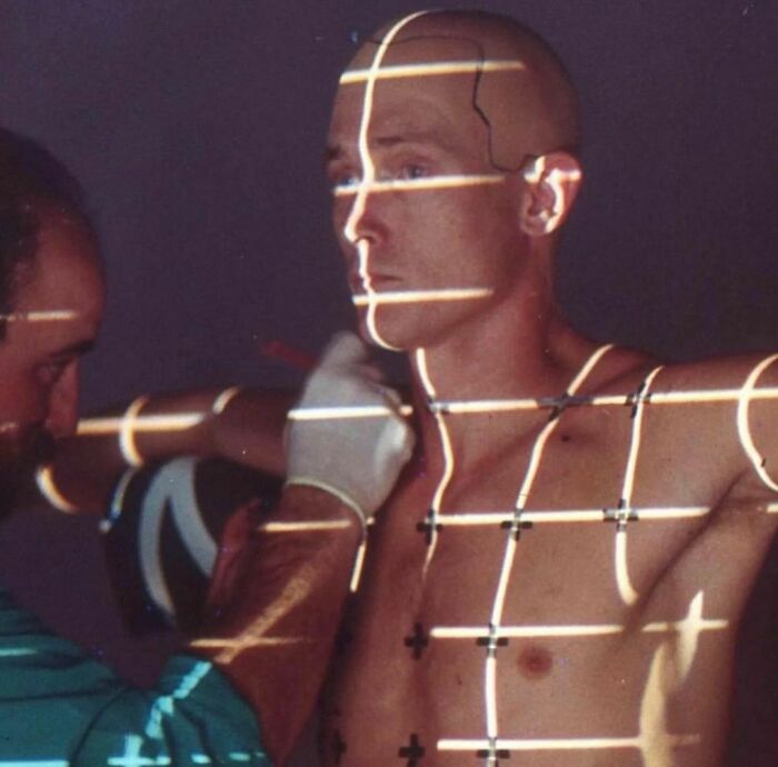 Person marked with lines and cross points during a scanning process, capturing 1990s technology imagery.
