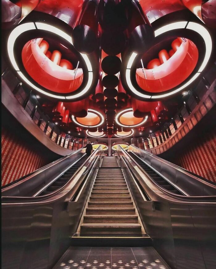 Retro futuristic subway escalator scene from the nineties showcasing vibrant red and circular lights.