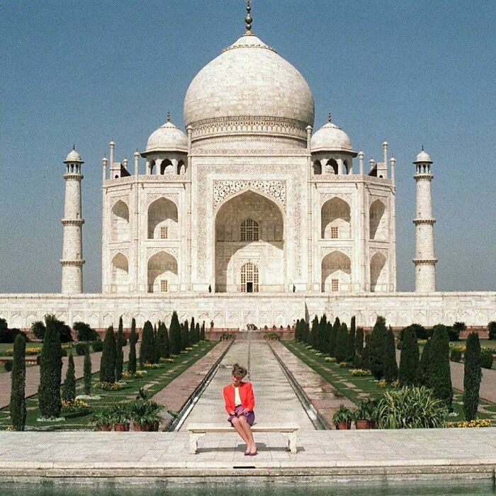 Person sitting in front of the Taj Mahal, embodying 'nineties anxiety' against an iconic backdrop.