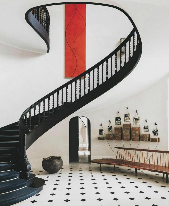 Nineties interior with a spiral staircase, checkered floor, and minimalist bench, capturing the unique style of the decade.