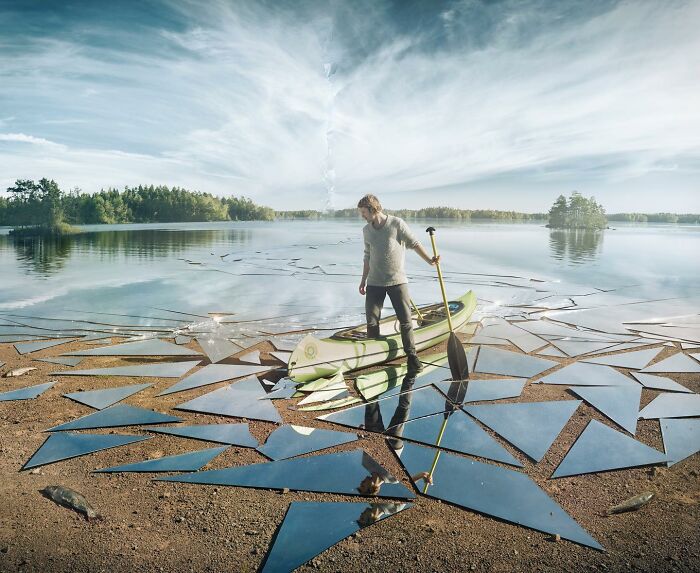 Man with kayak on shattered lake illusion by Swedish Photoshop master.