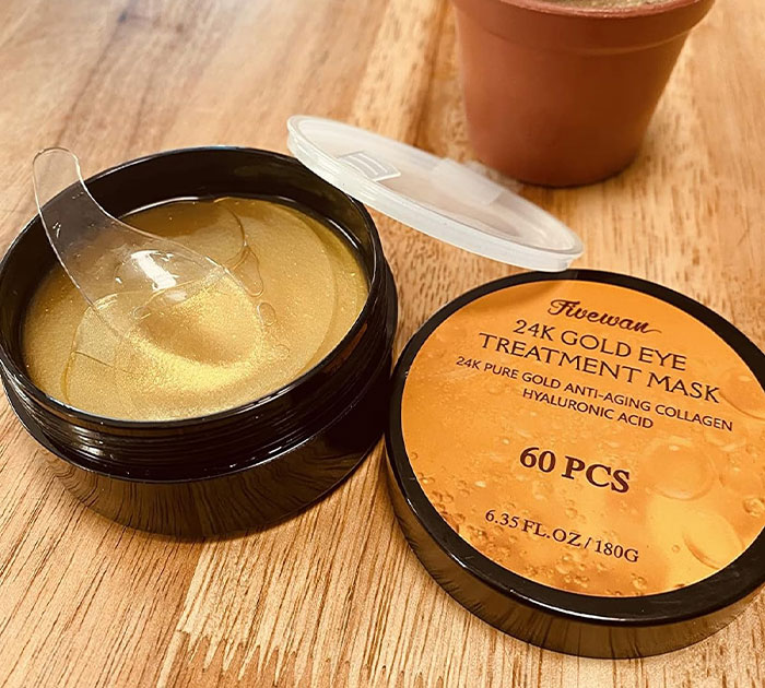 Woman smiling with under-eye and forehead gold patches, a cheerful and cheap Mother's Day gift idea.