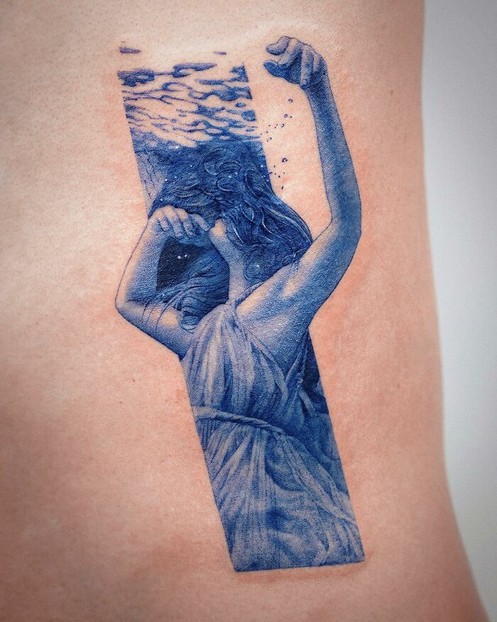 Realistic tattoo of a woman underwater, showing impeccable detail and artistry.
