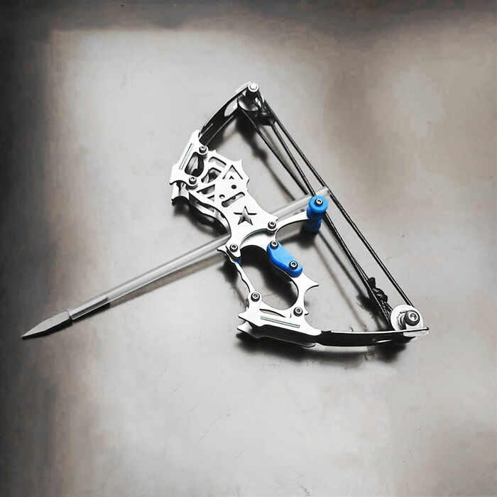 Compact crossbow-shaped pen with blue accents on a gray desk, a unique desk joy item for workday use.