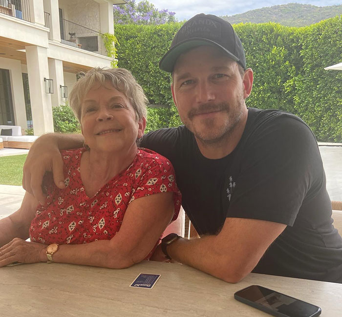Man in a black cap and his mother sitting outdoors, involved in controversial Mother's Day post.