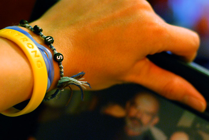 Close-up of a wrist wearing colorful bracelets, highlighting a nostalgic millennial trend like the whale tail style.