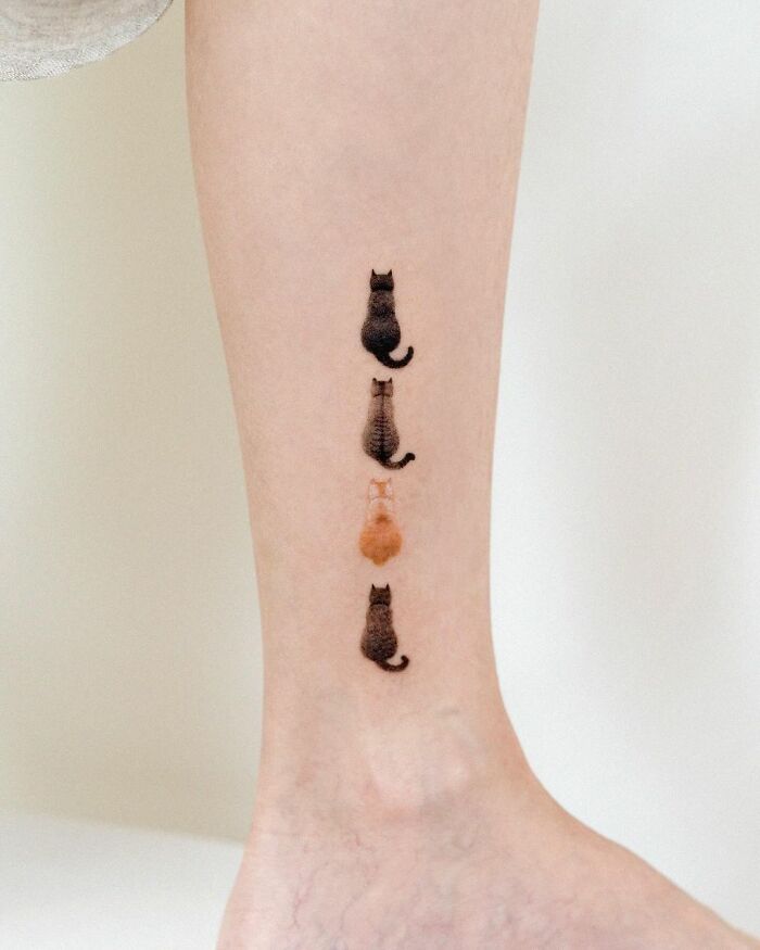 Cute pet portrait tattoos of four cats in a vertical line on a person's leg.