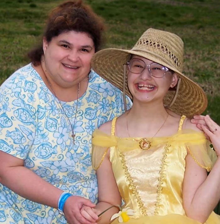Woman and girl smiling in a garden; girl wears a straw hat and yellow dress, SEO keyword: Gypsy Rose Blanchard.